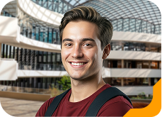 Estudante universitária sorrindo, usando bçusa azul com listas vermelhas, na Unidade de Ensino Einstein.